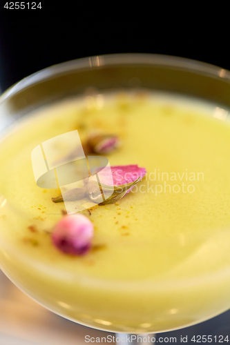 Image of close up of glass with creamy cocktail at bar