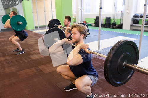 Image of group of men training with barbells in gym