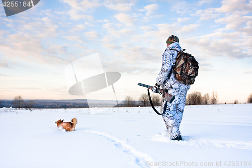 Image of hunter with a dog on a frosty day