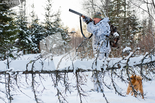 Image of hunter shooting in snowy forest