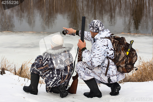 Image of hunter shows his son where the prey