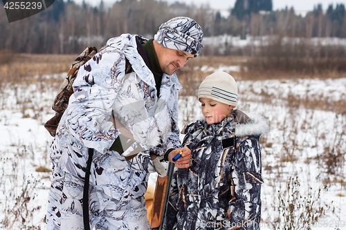 Image of hunter shows his son how to charge the gun