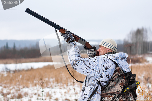 Image of hunter shooting on the snowy field