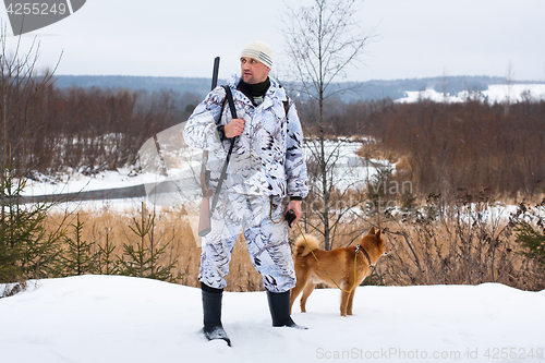 Image of hunter with dog in winter