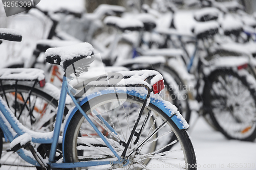 Image of snow covered bikes in the parking lot