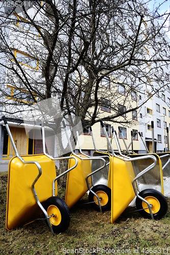 Image of lot of empty new yellow garden wheelbarrows