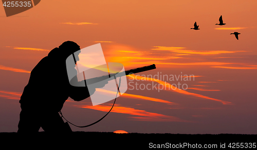 Image of the silhouette of a hunter at sunset
