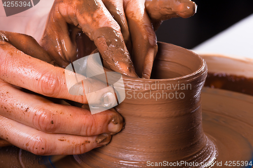 Image of closeup of hands working on pottery wheel