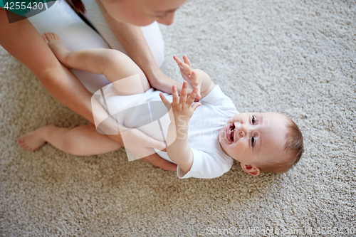 Image of happy mother playing with baby at home