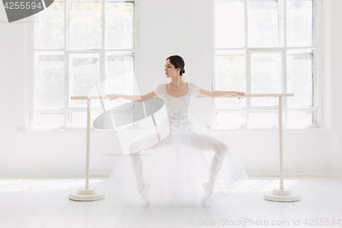 Image of Young and incredibly beautiful ballerina is posing and dancing in a white studio