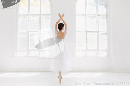 Image of Young and incredibly beautiful ballerina is posing and dancing in a white studio