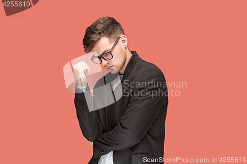 Image of Young handsome man in black suit and glasses isolated on red background