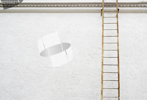 Image of White stucco wall with metal ladder