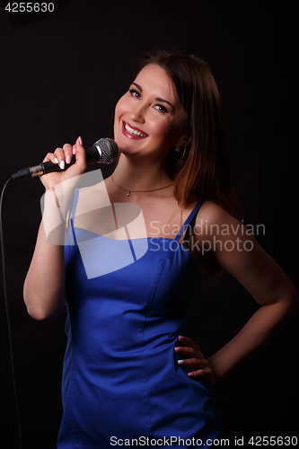 Image of Beautiful singing girl holds microphone
