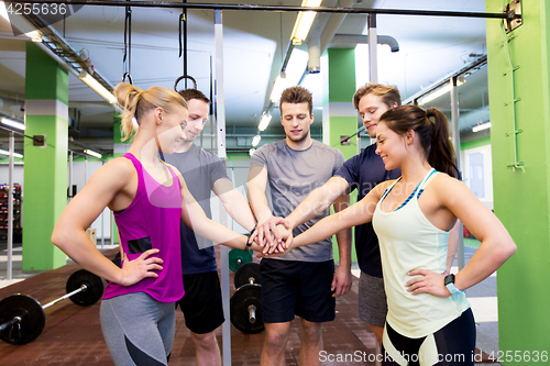 Image of group of friends holding hands together in gym