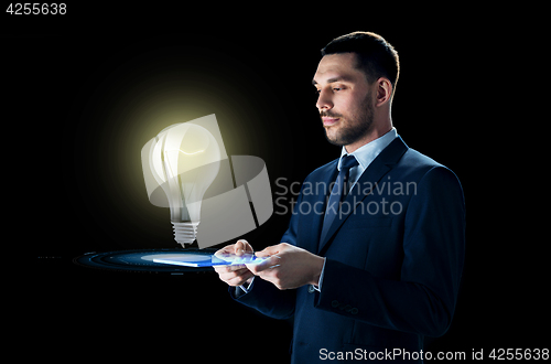 Image of businessman with tablet pc and lightbulb