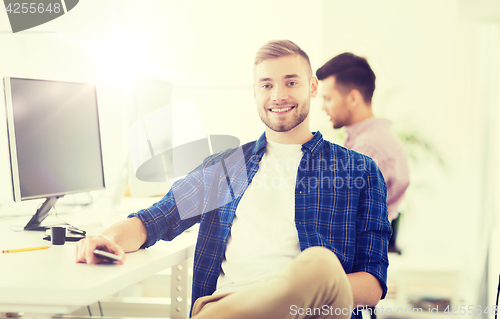 Image of happy creative man with cellphone at office