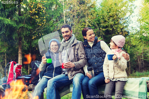 Image of happy family sitting on bench at camp fire