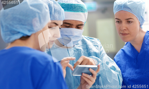 Image of group of surgeons with smartphone at hospital