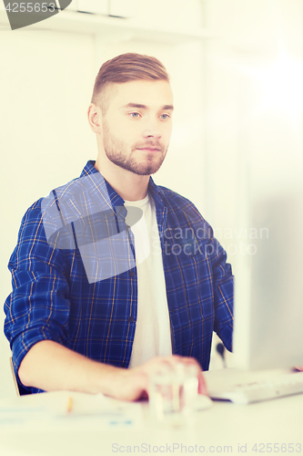 Image of creative man or student with computer at office