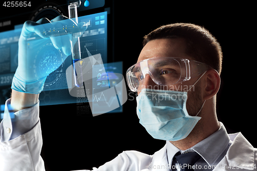 Image of scientist with test tube and virtual screen