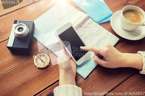 Image of close up of traveler hands with smartphone and map