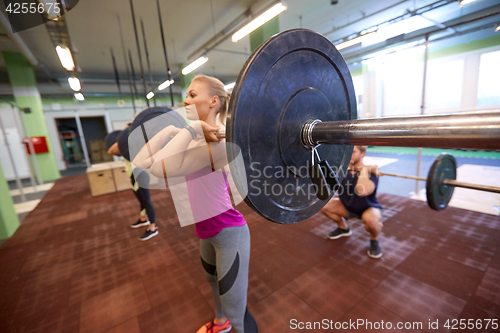 Image of group of people training with barbells in gym