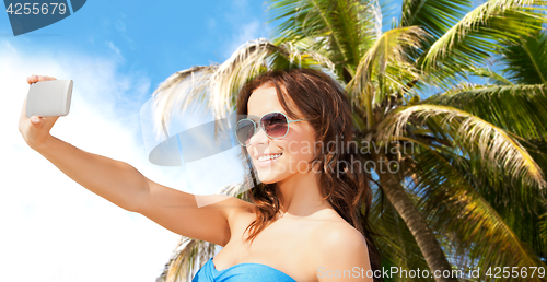 Image of woman in swimsuit taking selfie with smatphone