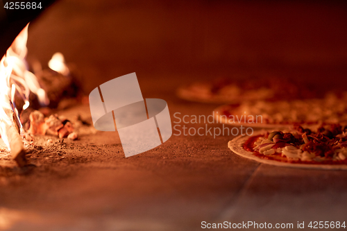 Image of pizza baking in oven at pizzeria