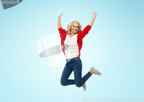 Image of smiling young woman jumping in air