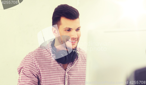 Image of creative man with headphones and computer