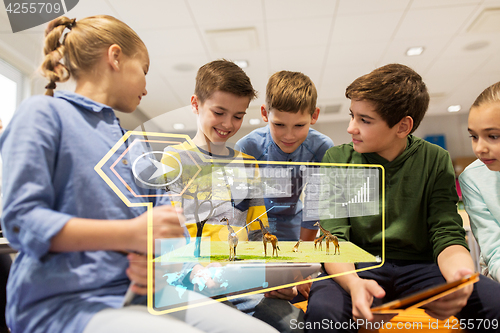 Image of group of happy children with tablet pc at school