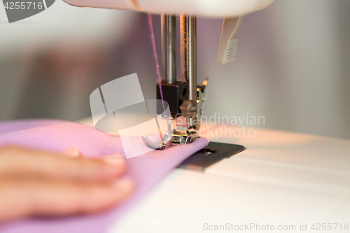 Image of sewing machine presser foot stitching fabric