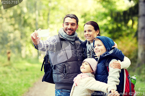 Image of family taking selfie with smartphone in woods