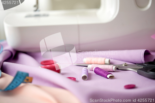 Image of sewing machine, scissors, buttons and fabric