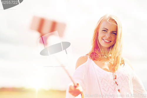 Image of happy young woman taking selfie by smartphone