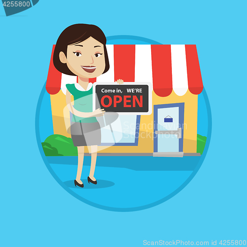 Image of Female shop owner holding open signboard.