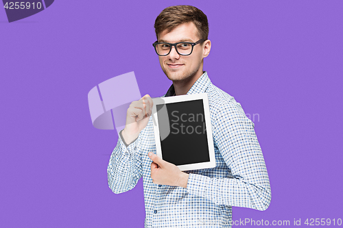 Image of The young man in a shirt working on laptop on lilac backgroundin