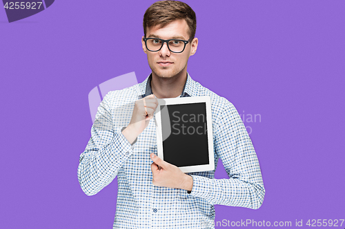 Image of The young man in a shirt working on laptop on lilac backgroundin