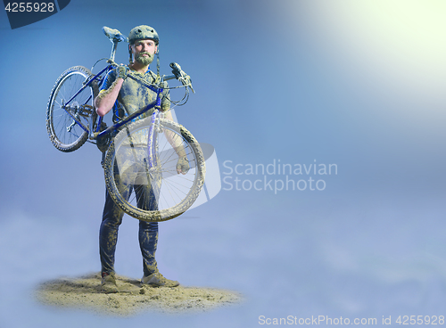 Image of The man with bike in sand standing on abstract background. Collage
