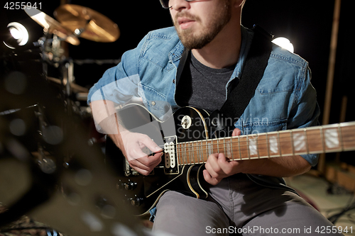 Image of man playing guitar at studio rehearsal