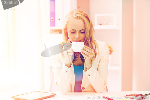 Image of happy businesswoman drinking coffee at office