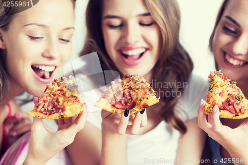 Image of happy friends or teen girls eating pizza at home