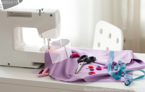 Image of sewing machine, scissors, buttons and fabric