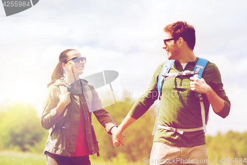 Image of happy couple with backpacks hiking outdoors