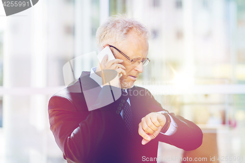 Image of senior businessman calling on smartphone in city