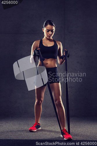 Image of woman with expander exercising in gym