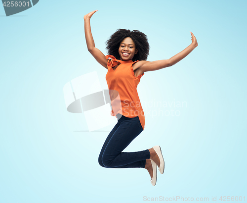 Image of happy african american woman jumping over white