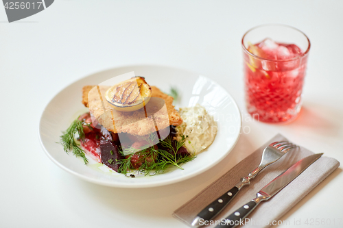 Image of close up of fish salad with roasted lemon on plate