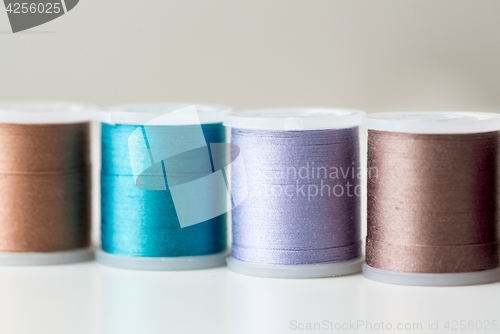 Image of row of colorful thread spools on table